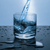 A glass with some water being poured into it