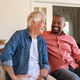Two people sitting on chairs talking and laughing