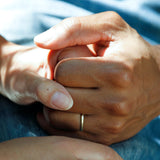 Two hands holding one another in a caring position