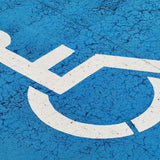 A photo of a disabled sign – a wheelchair – with a mottled blue backgroundA photo of a disabled sign – a wheelchair – with a mottled blue background