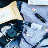 A close up of the content in an open suitcase – a shirt, camera, wet wipes, a book and some denim jeans