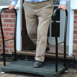 A man coming out of his front door and stepping onto the Bigfoot Half Step which has two handles in place