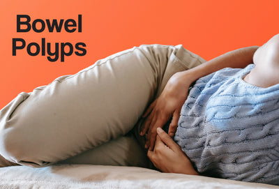 A person lying on a sofa clutching her stomach, as though in pain. The words – Bowel Polyps – can be seen