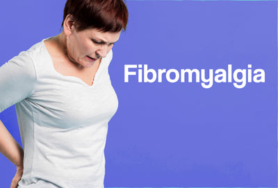 A middle aged woman, with her hands behind her back; she looks in pain. The word – Fibromyalgia – is visible