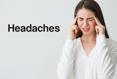 Woman holding her head as if she has a headache with the text headaches next to it