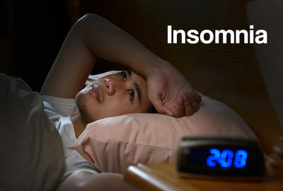 A young man lying in bed wide awake. The word – Insomnia – can be seen