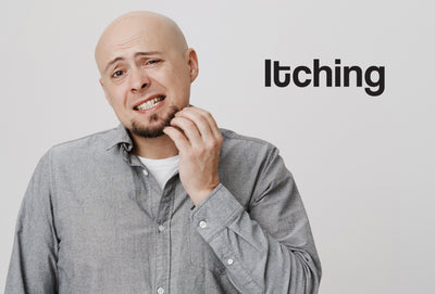 A bald man with a beard scratching his beard with the word itching in the top right