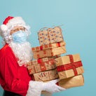 the image shows Santa Claus delivering presents and wearing a face mask