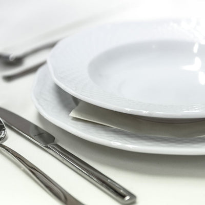 Dining set of white plates with cutlery and glass