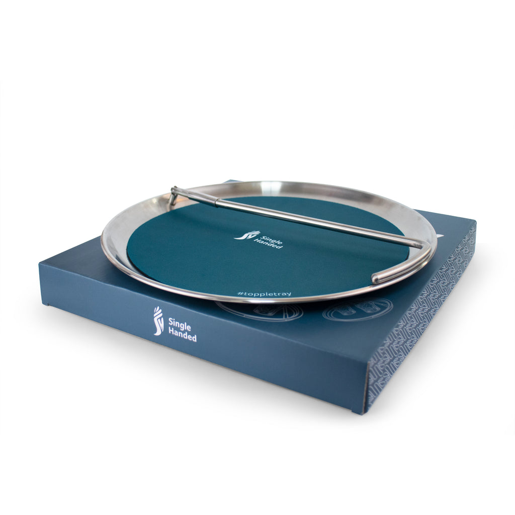 A Topple Tray with the handle folded, on top of the Topple Tray box.