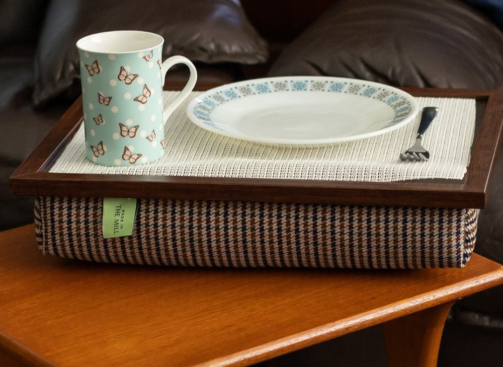 The luxury Dogtooth Lap Tray with bean bag on a table in a living room, with non slip matting, a mug, a plate and a fork on it.