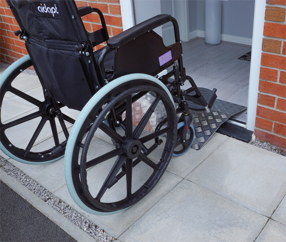 A Wheelchair going over an Aluminium Threshold Bridging Ramp