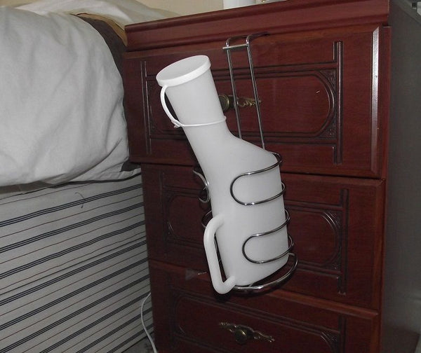 shows the Stainless Steel Urinal Bottle Holder hanging from a bedside cabinet 