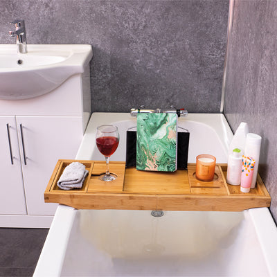 The Bed & Bath Tray Table being used on a bath with a glass of wine, candles, a flannel and a book, on it.