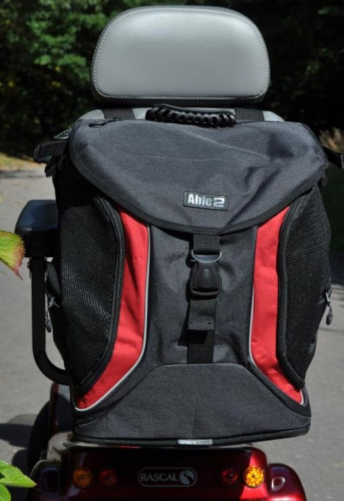 Image of the torba go bag fitted to the back of a mobility scooter in the grey/black option. The scooter is outside on a pavement in the sunshine. 
