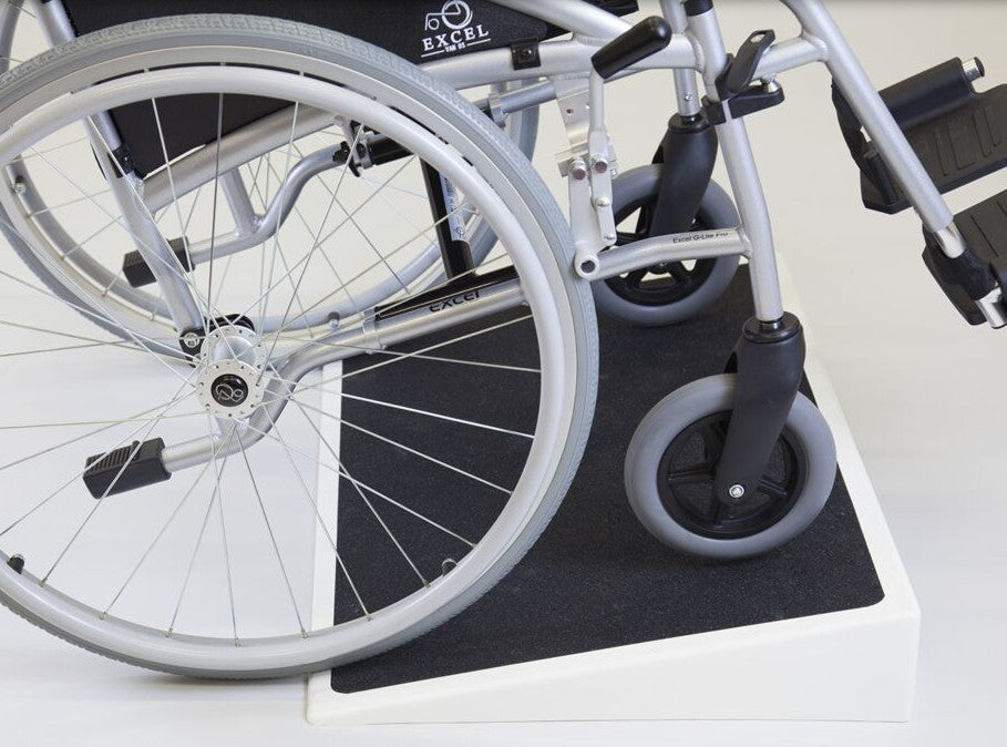 the image shows a wheelchair using a fibreglass threshold ramp