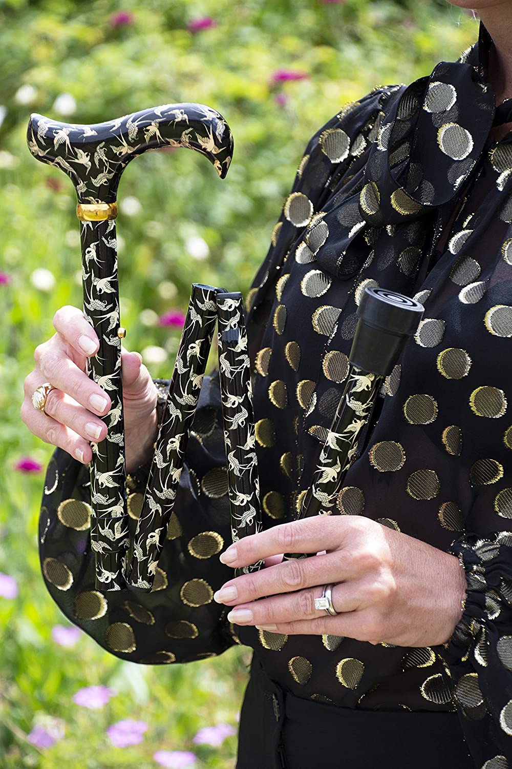 the image shows a woman holding the classic canes folding fashion derby cane with the swallows pattern