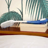 shows an Etac Long Handled Hair Brush resting on some books on a shelf