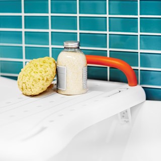 some bath lotion and a sponge on the etac fresh bath board