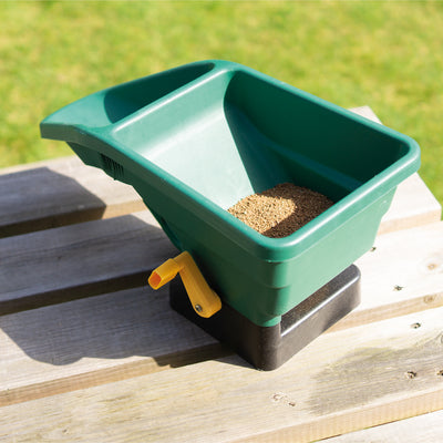 Home and Garden Manual Seed Spreader in use, full of seed.