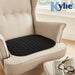 The Black Kylie Chair Pad on an armchair in a living room