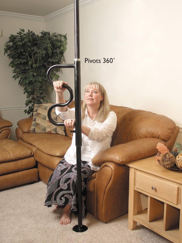 shows a woman with blonde hair sitting on a leather couch and holding on to the black version of the security pole