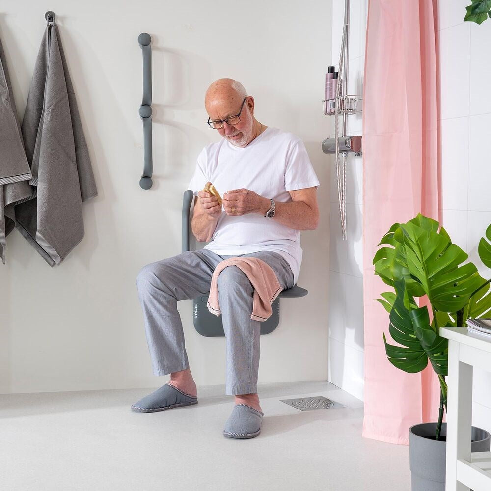 Man in his relaxing clothes, cleaning his nails on the Shower seat