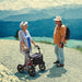 shows a woman chatting to man with a Dietz Taima Rollator XC on a scenic walk