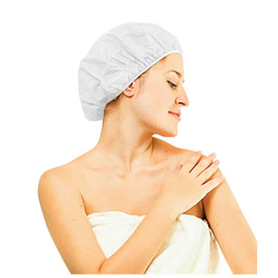 shows a woman wrapped in a white towel wearing a Moistened Shampoo Cap