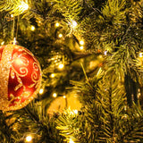 A close-up of a Christmas tree with lights and coloured baubles