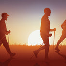 A drawing showing the silhouettes of three men walking, with each one holding a walking stick – the sun is setting in the background
