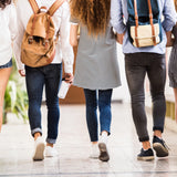 The backs of five teenagers, as they walk down a corridor