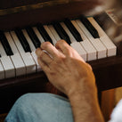 A picture of a left hand playing the piano
