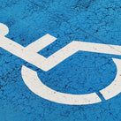A photo of a disabled sign – a wheelchair – with a mottled blue backgroundA photo of a disabled sign – a wheelchair – with a mottled blue background