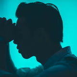 A silhouette of a man with his hands clenched to his face and is obviously in some pain