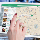 A close-up of two hands holding a tablet that has Google Maps on it