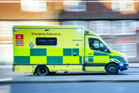 an ambulance going at full speed down a road