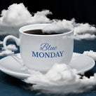 A cup and saucer. The cup is filled with black coffee. The background is dark with white clouds. The words – Blue Monday – can be seen
