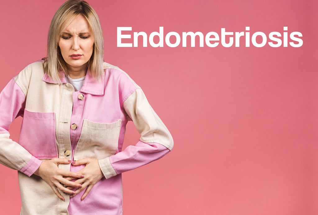 A middle aged woman in a checked (pink and white) shirt, is clutching her stomach, as though in pain. The word – Endometriosis – can be seen
