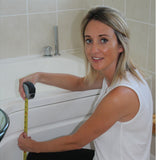Kate measuring the height of a bath with a tape measure