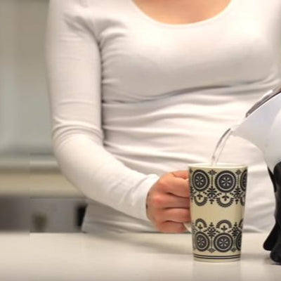 Woman pouring drink with Uccello Safety Kettle & Tipper
