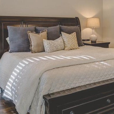 the image shows a comfy bed with some scatter cushions on it
