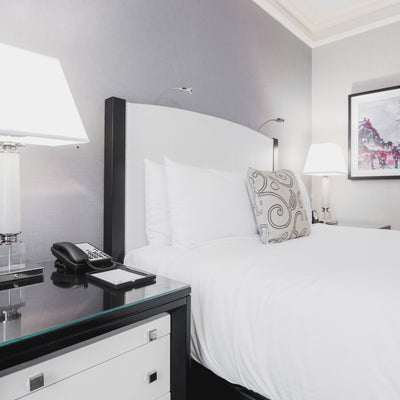 White profiling bed next to bedside cabinet with lamp