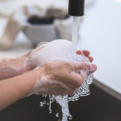 Person washing hands under running water