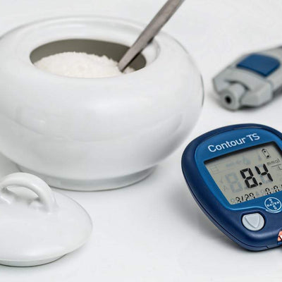 Bowl of sugar next to blood glucose monitor