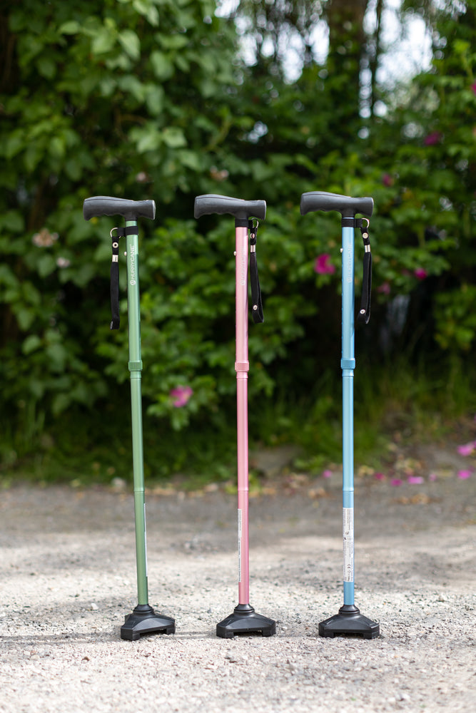 the three colours of hurrycane walking stick, green, pink, and blue, pictured outside