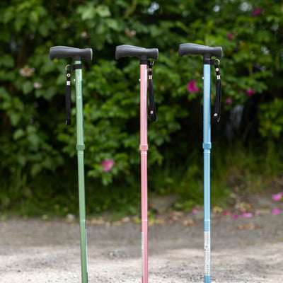 the three colours of hurrycane walking stick, green, pink, and blue, pictured outside