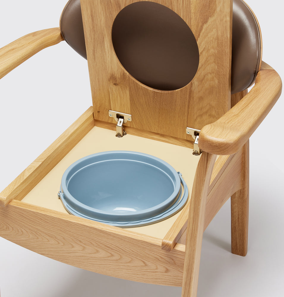 the image shows a close up of the pan on the mole coloured oak commode chair the 