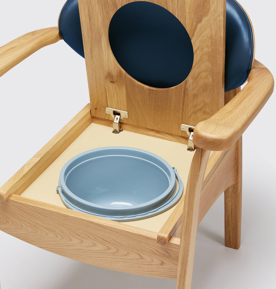 the image shows a close up of the pan on the blue oak commode chair
