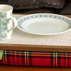 The Royal Stewart Red Tartan Lap Tray with Bean Bag on a table with a mug, plate and fork on it